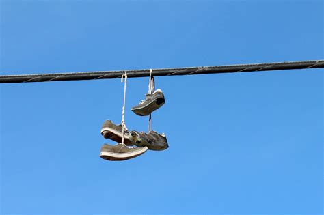 why do people throw shoes over power lines.